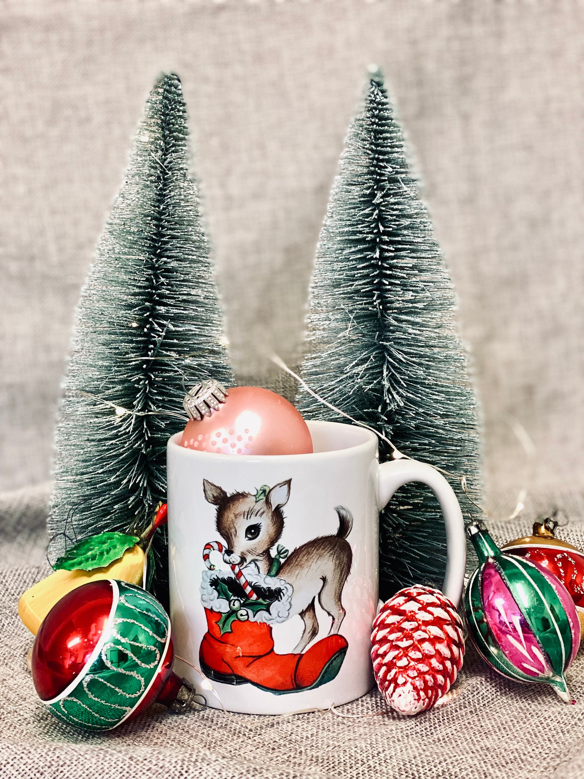 Christmas mug with a reindeer surrounded by vintage baubles and Christmas tree ornaments.